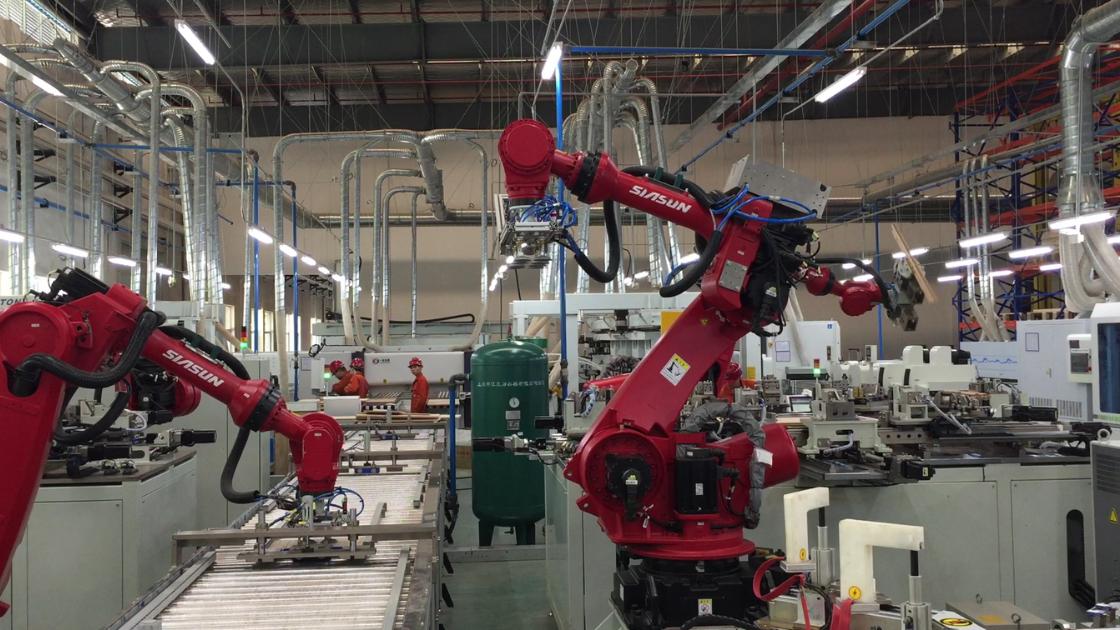 Nowoczesna fabryka: inżynierowie i roboty współpracują, infografiki obalają mity o automatyzacji.